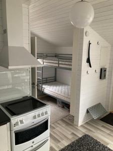 a kitchen with a stove and a bunk bed at Compact living Laxvik in a cottage in Halmstad