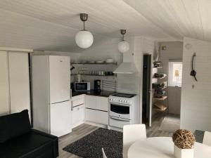 a kitchen with a white refrigerator and a stove at Compact living Laxvik in a cottage in Halmstad