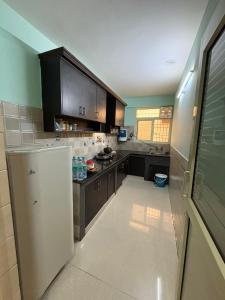 a kitchen with brown cabinets and a white refrigerator at Pine View Guest House in Nāhan