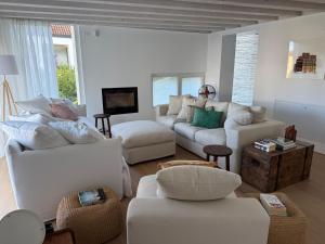 a living room with white couches and chairs at Villa Prince Garda in Salò