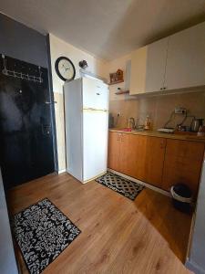 a kitchen with a refrigerator and a clock on the wall at Slice of life in Qiryat Motzkin
