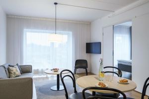 a living room with a table and a couch at Story Living Lidingö in Stockholm