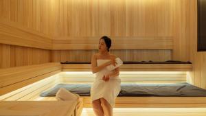 a woman is standing in a sauna at Anook Hotel & Spa Bucheon Sangdong in Bucheon
