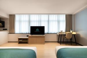 a hotel room with two beds and a television at Guang Dong Hotel in Guangzhou