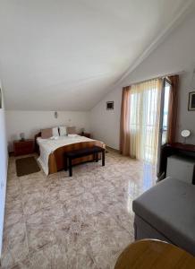 a bedroom with a bed and a large window at Hotel Max in Baošići