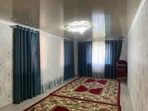 a room with curtains and a rug and a chandelier at Мой дом, жилье in Zarger