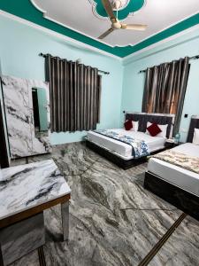 two beds in a room with blue walls at Bhagirathi Residency in Rishīkesh