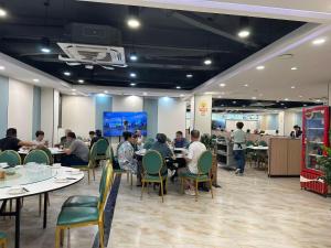 a group of people sitting at tables in a restaurant at Guang Dong Hotel in Guangzhou