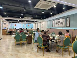 a group of people sitting at tables in a restaurant at Guang Dong Hotel in Guangzhou