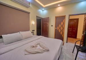 a bedroom with two beds with a towel on it at De Waves Varkala by VOYE HOMES - Just 1 Km from Varkala Cliff and Beach in Varkala +65 photos