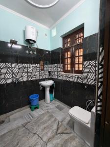 a bathroom with a toilet and a sink at Bhagirathi Residency in Rishīkesh