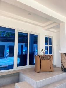 a wicker chair sitting on a patio with windows at Turtle's Cavern Oceanfront Resort in San Juan