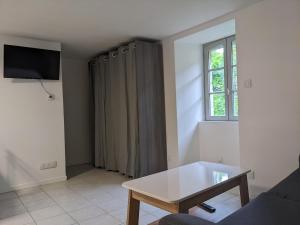 a living room with a couch and a table at Le Petit Nid de Martel in Martel