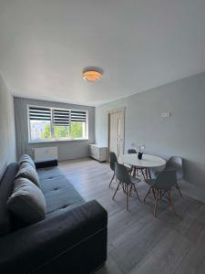 a living room with a couch and a table at Geri apartamentai in Naujoji Akmenė