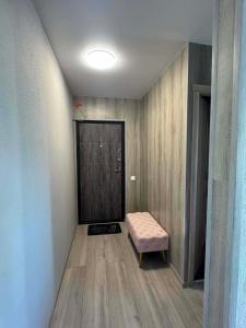 a small room with a bench and a door at Geri apartamentai in Naujoji Akmenė