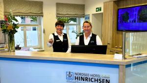 Zwei Personen stehen hinter einem Tresen in einem Laden in der Unterkunft Nordsee-Hotel Hinrichsen in Husum