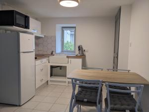 a kitchen with a table and chairs and a refrigerator at Le Petit Nid de Martel in Martel