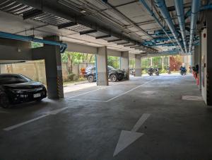 a parking lot with cars and motorcycles parked in it at Boat Avenue condo in Bang Tao Beach