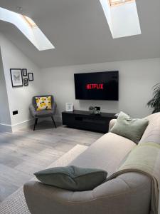 a living room with a couch and a tv at The Loft in Clonmore