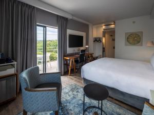 a hotel room with a bed and a desk at ANEW Hotel Roodepoort Johannesburg in Roodepoort