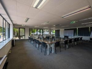 a conference room with a long table and chairs at ANEW Hotel Roodepoort Johannesburg in Roodepoort