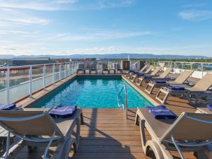 a deck with chairs and a swimming pool on a building at H10 Salauris Palace in Salou +48 photos