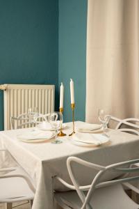a table with a white tablecloth and two candles on it at Hyper Centre Place Kléber Appart in Strasbourg