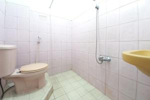 a bathroom with a toilet and a sink at Urbanview Hotel Grand Palem near Alun Alun Batu in Songgoriti +29 photos