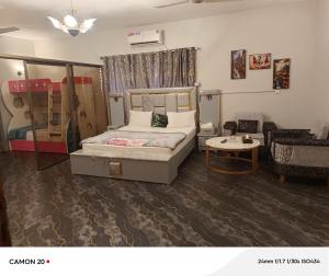 a bedroom with a bed and a living room at Hotel Royal Inn in Karachi