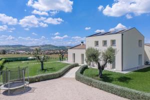 a white house with a garden and a basketball hoop at Villa Alice in Montecosaro