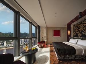 a hotel room with a large bed and large windows at Aranciel 阿岚若 High-Rise River View Hotel -Jiefangbei Area-Hongya Cave in Chongqing