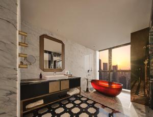 a bathroom with a red tub and a sink at Aranciel 阿岚若 High-Rise River View Hotel -Jiefangbei Area-Hongya Cave in Chongqing +88 photos