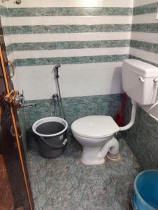 a bathroom with a toilet and a bucket at Venya Vihar Vizag MVP AC Deluxe 1 BHK Studio Apartment in Visakhapatnam
