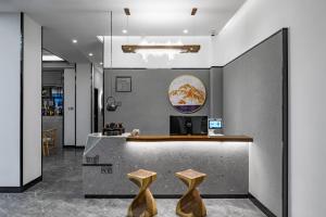 a restaurant with a counter with two wooden stools at Ruqi Hotel in Yangshuo