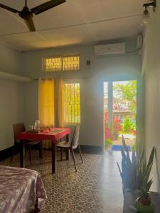 a room with a red table and chairs and a bed at Org Retreat & Farmstay in Guwahati