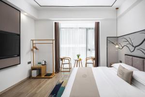 a hotel room with a bed and a tv at Ruqi Hotel in Yangshuo
