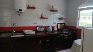 a kitchen with a counter with a sink and a microwave at Mediterraneo House in Tangier +9 photos