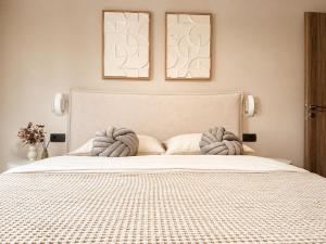 a bedroom with a large white bed with two pictures on the wall at Luxury casa in Nea Makri