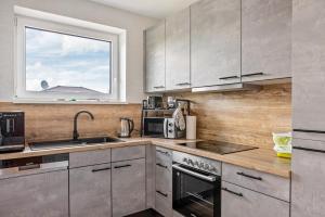 a kitchen with stainless steel appliances and a window at Ferienwohnung "Beim Tannenbaum" in Reichensachsen