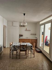 a kitchen with a table and chairs in a room at bord de mer in Leucate-Plage