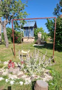 a swing in a yard with a garden at Dragačevska kuća na bregu- Heritage House in Viča
