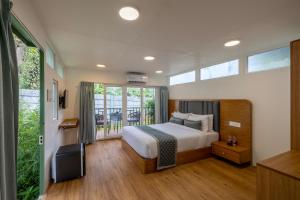 a bedroom with a bed and a large window at Ashvana Resort in Nidigere +48 photos