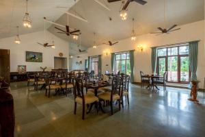 a large dining room with tables and chairs at Ashvana Resort in Nidigere