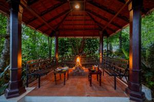 a fire pit on a patio with trees in the background at Ashvana Resort in Nidigere