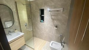 a bathroom with a sink and a shower with a mirror at Apex Hills تلال القمة in Dār Sawdāʼ +20 photos