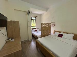 a bedroom with two beds and a flat screen tv at Ba Doan 2 in Con Dao