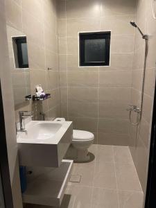 a bathroom with a sink and a toilet and a shower at أواسِيس Oasis Stay in Al Muḩassin