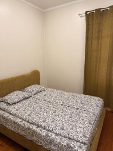 a bedroom with a bed and a curtain at LIINA apartment in Vahtseliina