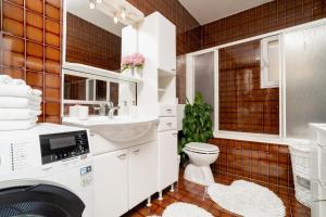 a bathroom with a washer and dryer in it at Apartments Doris in Zadar +82 photos