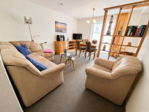 a living room with two couches and a dining room at Haus Meeresrauschen in Rerik